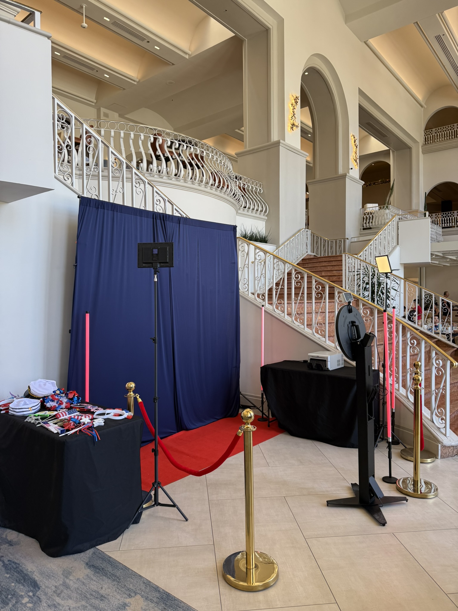 Photo booth activation in grand hotel lobby with patriotic backdrop and ornate staircase, Tucson AZ